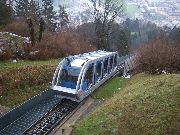 The same vehicle, now on one of the steep sections of track. The blue cabins are now stepped up in relation to each other, and have rotated in relation to the grey frame, but each cabin itself remains horizontal. Clever...By User:My Friend (Own work) [GFDL or CC-BY-SA-3.0], via Wikimedia Commons